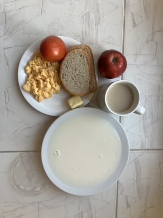 Kawa z mlekiem, zupa mleczna, jajecznica, masło, pieczywo, pomidor oraz jabłko