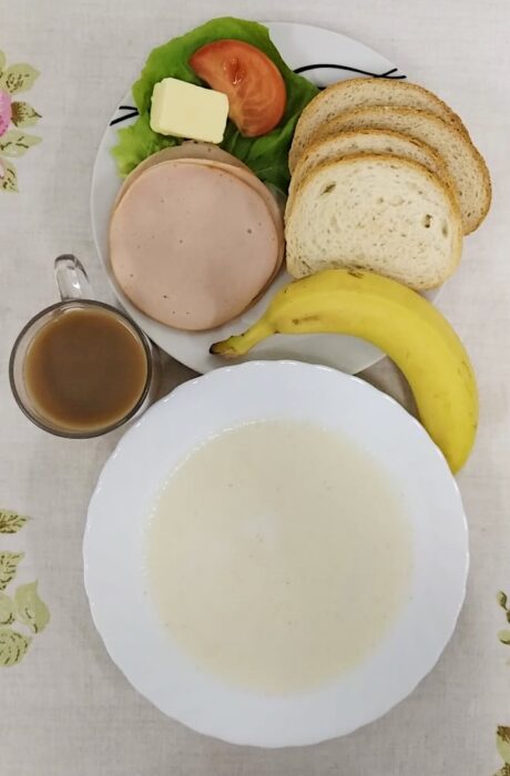 Zupa mleczna, pieczywo, masło, wędlina, sałata, pomidor, banan, kawa z mlekiem.