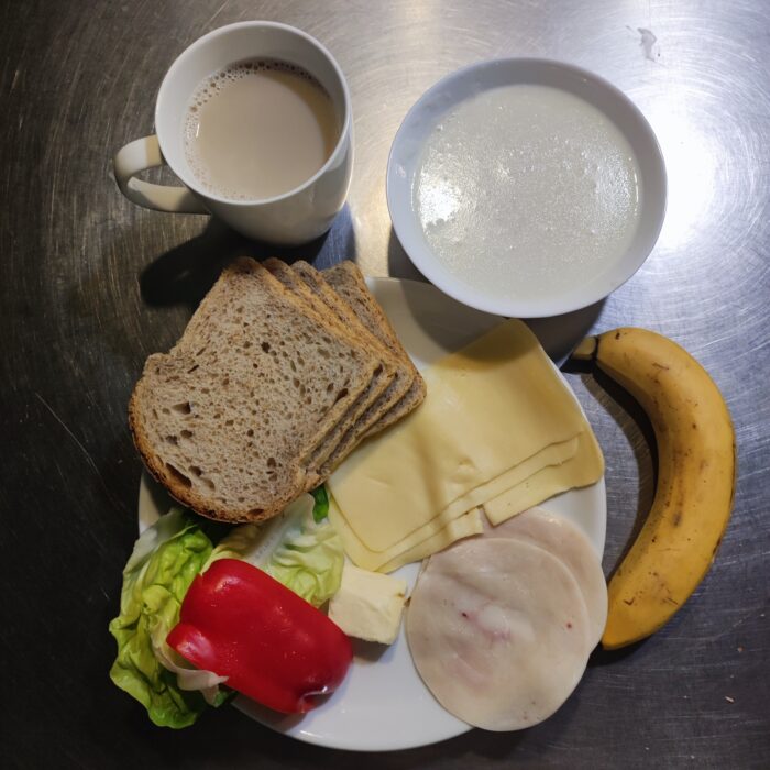 Zupa mleczna, kawa z mlekiem, chleb graham, masło, ser żółty, wędlina, sałata, papryka, banan