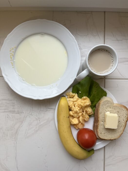Kasza kukurydziana na mleku, kawa z mlekiem, pieczywo, masło, jajecznica, pomidor, banan