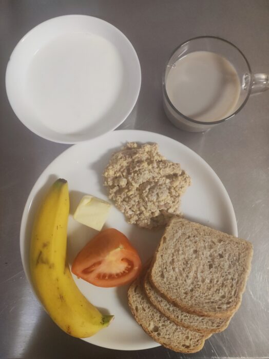 Zupa mleczna, kawa, chleb graham, pasta z tuńczyka i jajka, masło, pomidor, banan