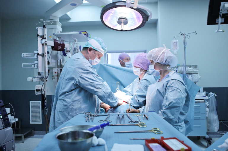 Stół operacyjny i 4 operujących chirurgów