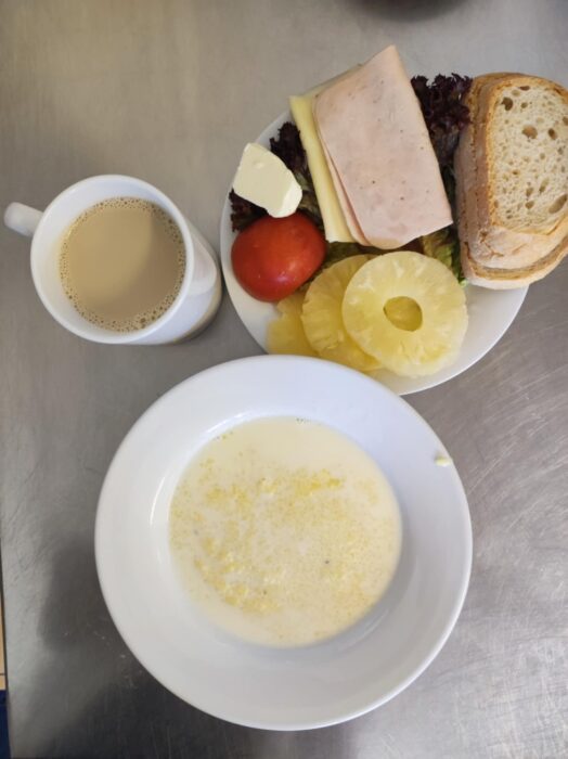 Kasza kukurydziana, pieczywo, masło, ser żółty, wędlina, sałata, pomidor, ananas, kawa